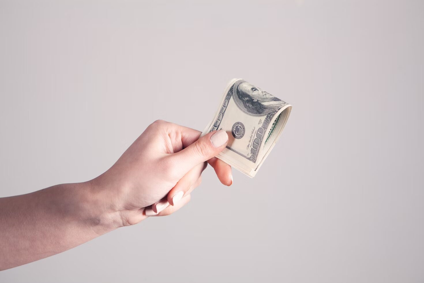 Woman's hand holding a dollar bills