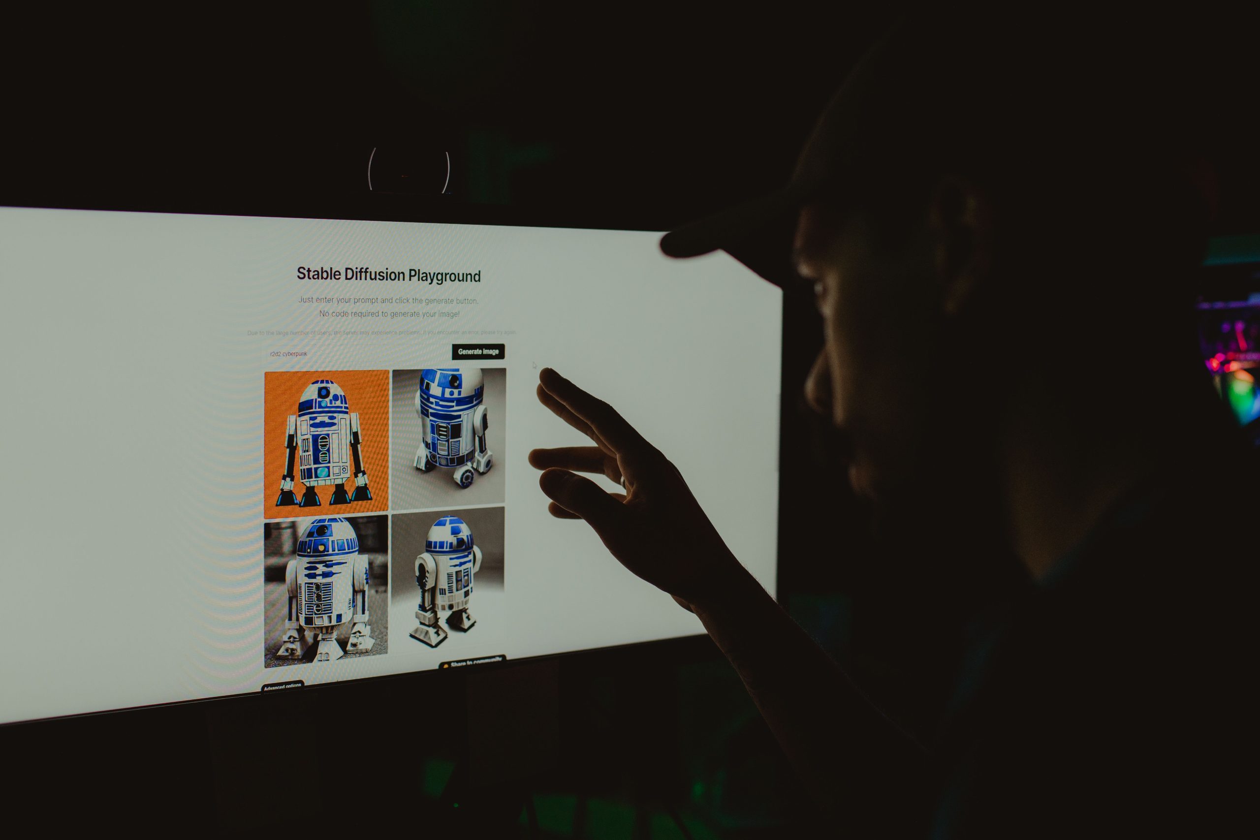 Person interacting with AI-generated images displayed on a screen in a dark creative workspace