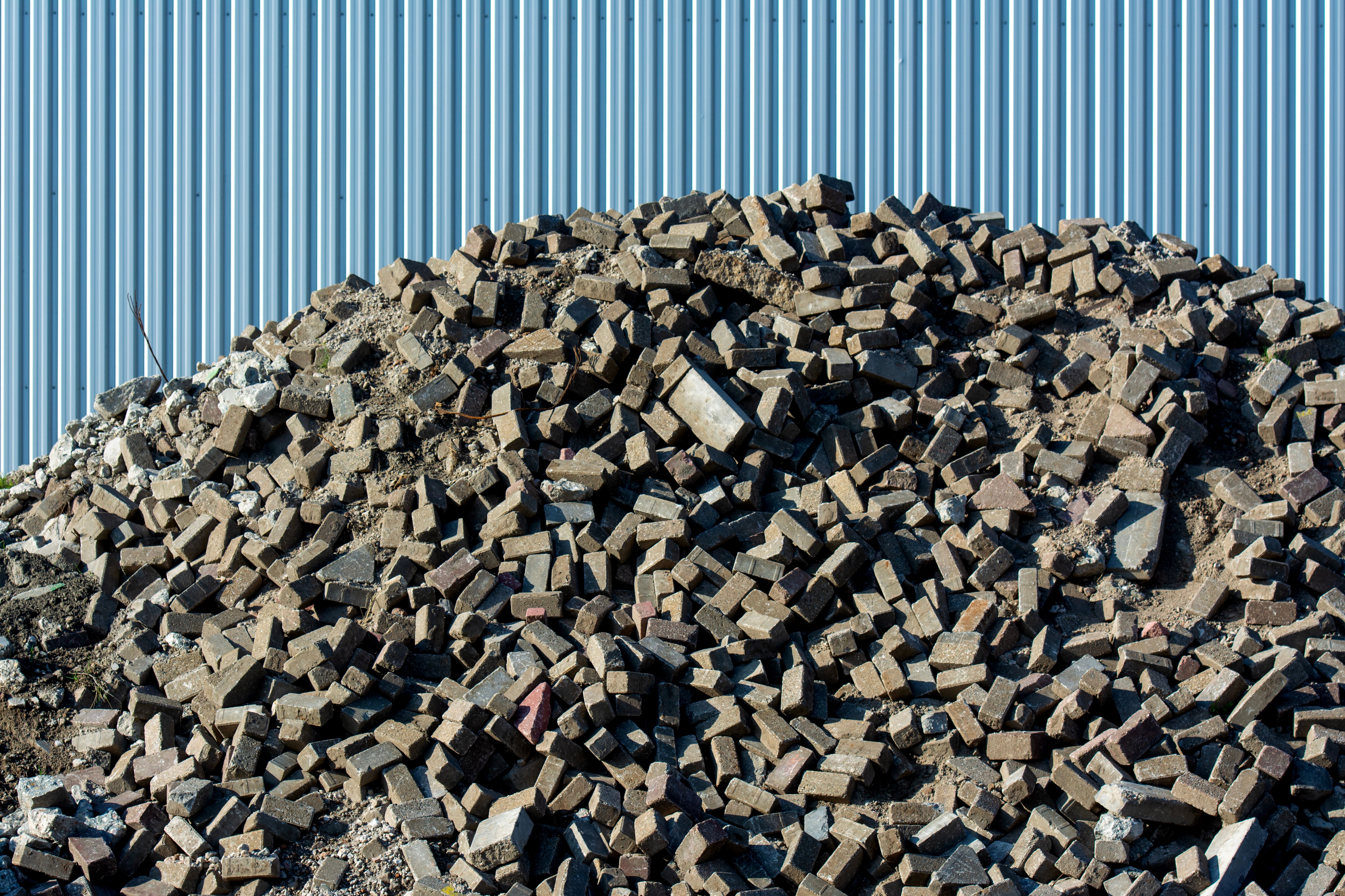 A pile of brick rubble and demolition debris, representing the challenge and potential of construction material reuse.
