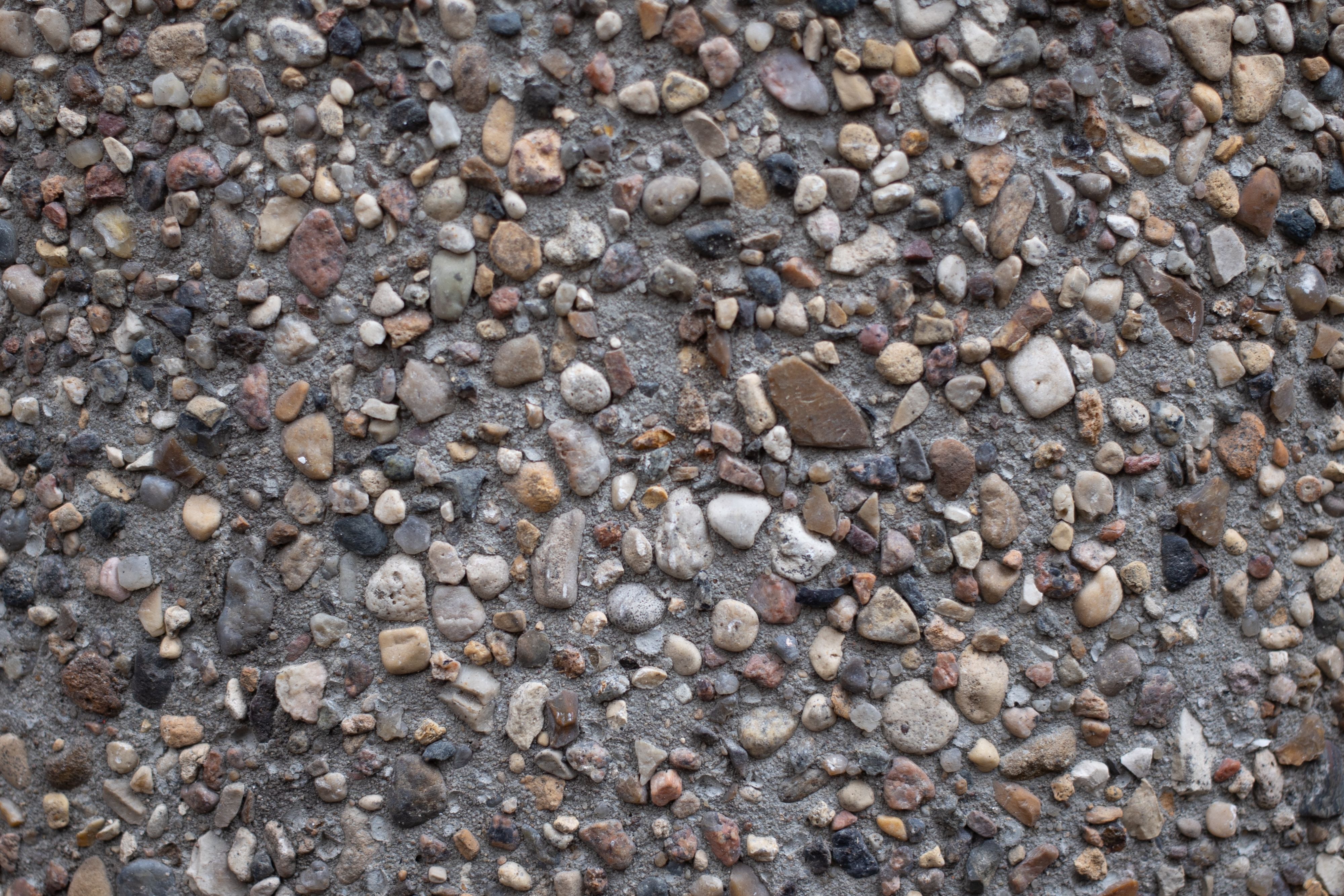 Close-up of concrete containing visible stone fragments, illustrating aggregate-rich construction materials.