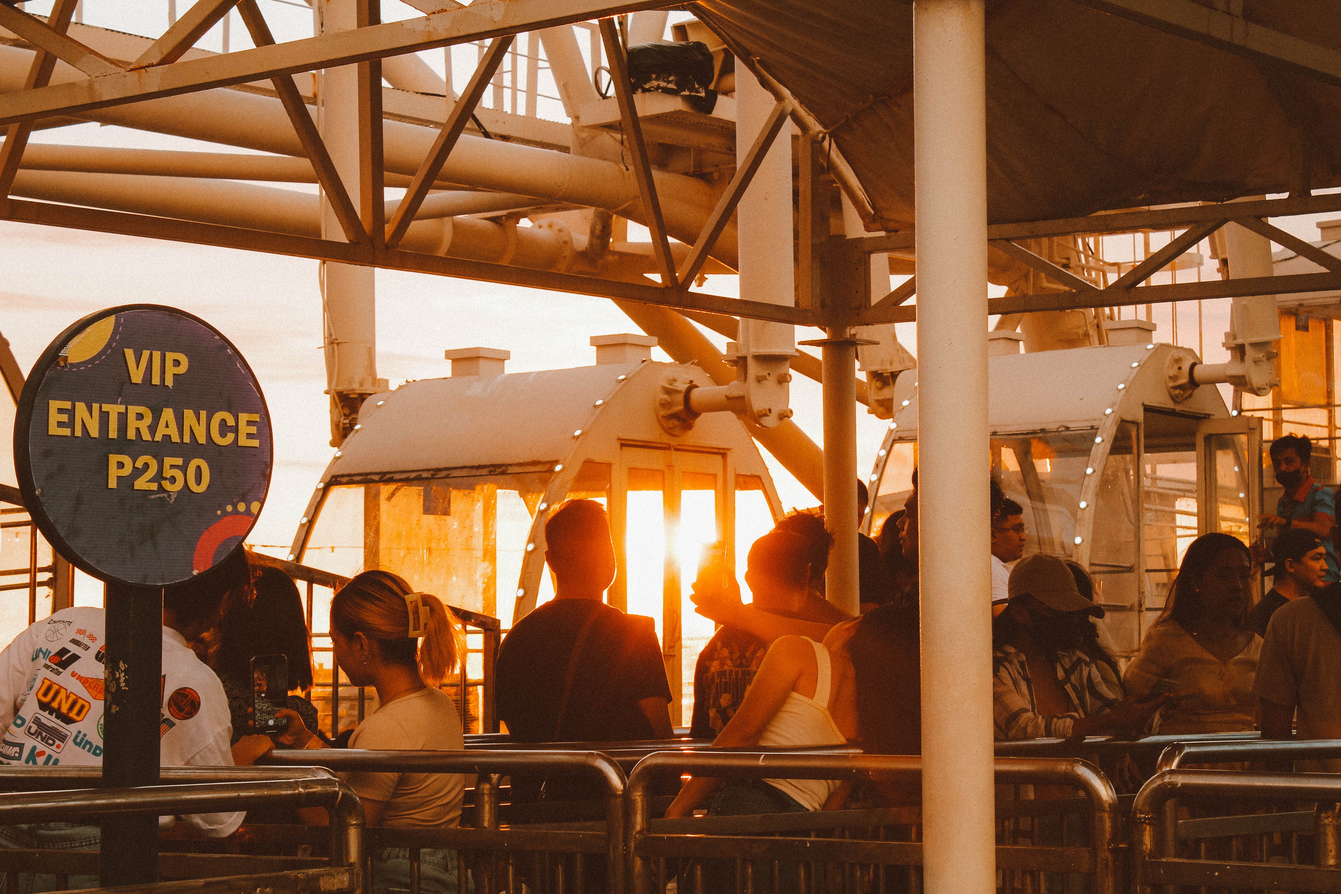 Visitors queue near a VIP entrance sign at an attraction, suggesting the status and convenience of privileged access.